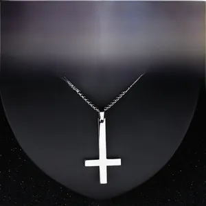 Close-up of polished stainless steel inverted cross pendant on a fine silver box chain