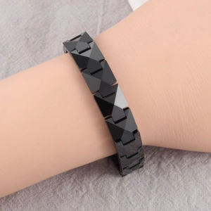 Macro detail of geometric pyramid links on a black magnetic ceramic bracelet for men and women