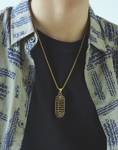 Detailed view of a golden abacus pendant necklace with Fu character on male model