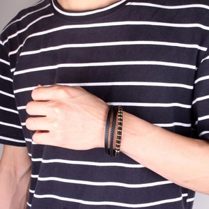 Close-up of multilayer black leather woven bracelet with metal beads on male wrist