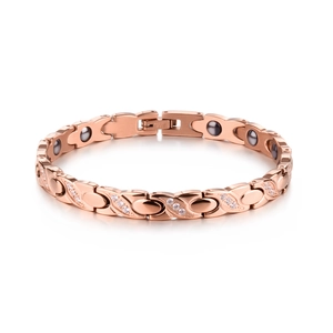 Detail of rose gold X-shaped bracelet with cubic zirconia and magnetic therapy stones