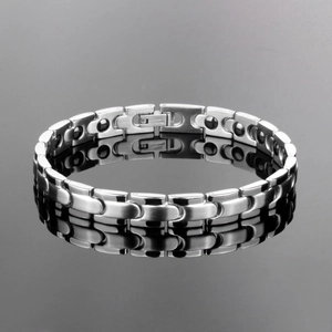 Polished silver stainless steel magnetic link bracelet for men on a black reflective surface