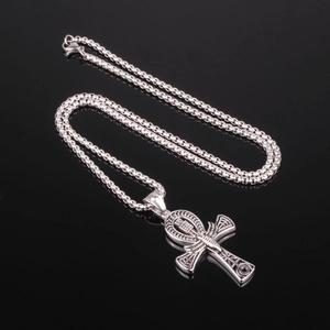 Detalle del colgante cruz Ankh plateado con cadena de caja sobre reflejo de espejo negro