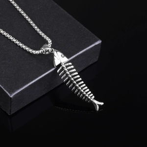 Gros plan du pendentif arête de poisson vintage avec sa chaîne à billes en acier fin