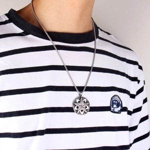 Close-up of retro hollow pentagram star pendant on a steel chain worn by a male model