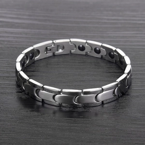 Detail of brushed silver magnetic therapy bracelet with health magnets on wood surface