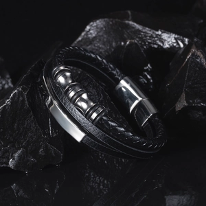 Detail of multi-layer black braided leather bracelet with silver stainless magnetic clasp