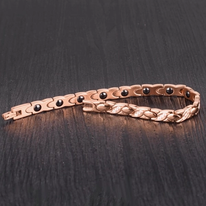Detail of rose gold magnetic bracelet featuring twisted X links and clear zircon stones