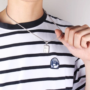 Dettaglio di una collana vintage in acciaio al titanio con ciondolo a croce rettangolare