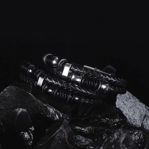 Ensemble de bracelets en cuir tressé et acier pour homme sur pierre volcanique noire