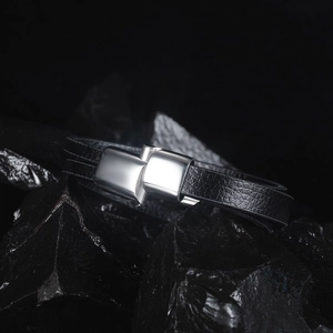 Détail d'un bracelet en cuir noir multicouche avec fermoir magnétique en métal argenté