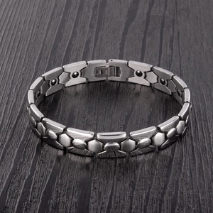 Pulsera magnética de acero inoxidable pulido para hombres y mujeres sobre madera