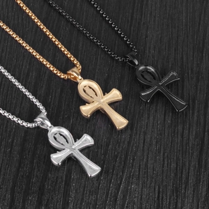 Colgantes de cruz Ankh vintage en oro, plata y negro sobre un fondo de metal oscuro