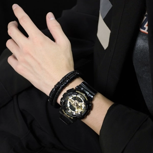 Montre de sport homme noir et or avec bracelet en cuir tressé au poignet d'un mannequin