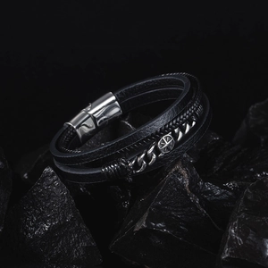 Detail of multi-layer black leather bracelet with star motif and magnetic steel clasp