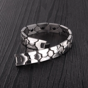 Detalle de una pulsera magnética de acero de titanio plateado con un cierre desplegable
