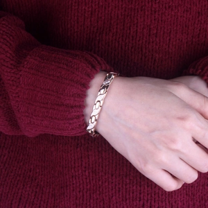 Detailed view of rose gold leaf-shaped bracelet links with sparkling white zircon settings