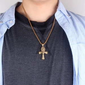 Detalle del colgante de cruz Ankh dorada con grabados egipcios en una cadena de cuentas