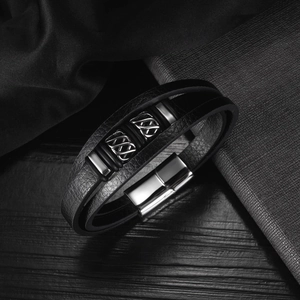 Detail of multi-layer black leather men's bracelet with woven metal beads and magnetic clasp