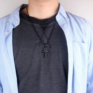 Detalle del colgante de cruz Ankh en negro mate con cadena de bolas para hombre