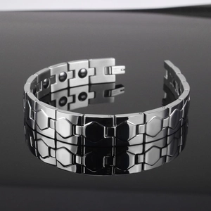 Macro detail of men's stainless steel magnetic link bracelet with brushed hexagon facets