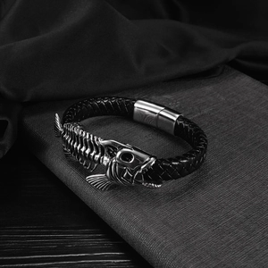 Detailed macro view of black braided leather men's bracelet with silver fish bone ornament