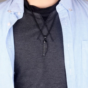 Détail du pendentif arête de poisson noir de style punk sur une chaîne en acier titane