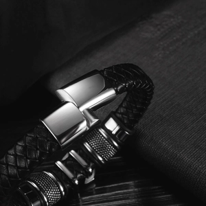 Close-up of black braided leather bracelet with polished magnetic clasp and metal rings