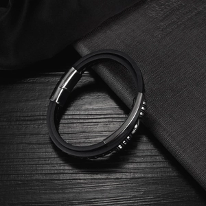 Detail of multi-layered black silicone men's bracelet with polished magnetic steel clasp