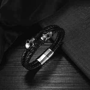 Detail of double-layer woven leather men's bracelet with silver metal skull accents