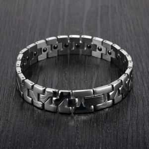Macro detail of men's health bracelet featuring brushed steel links and black magnets