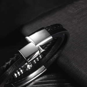 Detailed close-up of multilayer black leather men's bracelet with polished metal clasp
