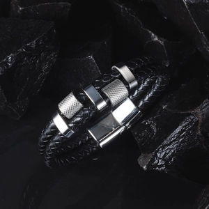 Macro view of double-layer braided black leather bracelet with silver metal textures