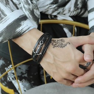Detail of multilayer black leather anchor bracelet for men with nautical punk style
