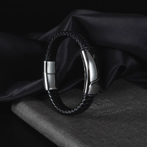 Dettaglio del bracciale in pelle nera intrecciata con chiusura lucida in acciaio argento