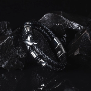 Detailed view of black woven leather bracelet with dolphin bead and stainless steel clasp