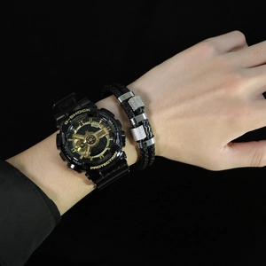 Close-up of black braided leather bracelet with silver accents and tactical sports watch