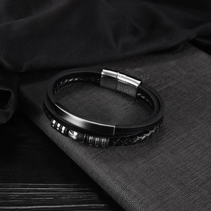 Detail of multi-layer black leather bracelet with silver magnetic clasp and metal sliders
