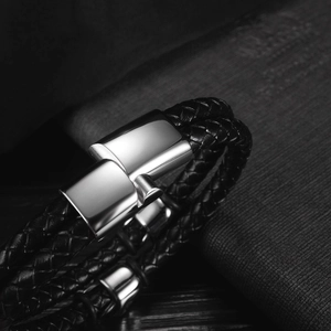 Close-up of multi-layer black braided leather bracelet with polished metal magnetic clasp