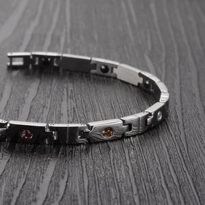 Macro detail of titanium magnetic bracelet with colorful crystals and brushed metal finish