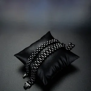 Gros plan de bracelets de montre en acier inoxydable noir sur un coussin en cuir
