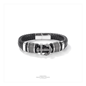 Detail shot of black braided leather bracelet with silver anchor charm and magnetic clasp