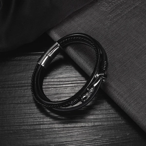 Detail of multi-layer braided leather bracelet with silver magnetic clasp and anchor charm