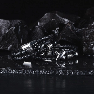 Macro detail of men's braided black leather bracelet with polished stainless steel beads