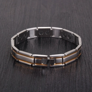Makro-Detail des Magnettherapie-Armbands mit zweifarbigen Gliedern in Gold und Edelstahl
