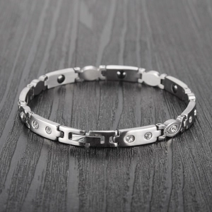 Close-up of silver magnetic therapy bracelet with inset rhinestones and metal links