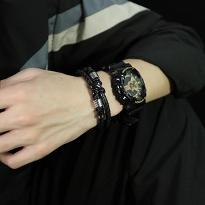 Detail of men's double-layer black braided leather bracelet with steel rings and metal clasp