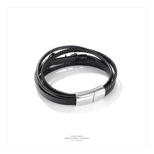 Close-up of black braided leather layers and polished steel magnetic clasp on men's bracelet