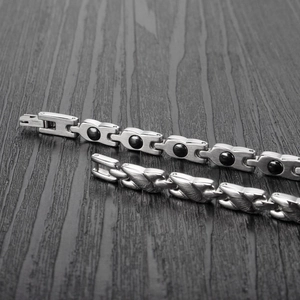 Magnetische Herren-Gesundheitsarmbänder aus Edelstahl in Silber und Schwarz auf Holz