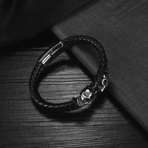Men's multi-layer black braided leather bracelet with silver skull charms and magnetic clasp